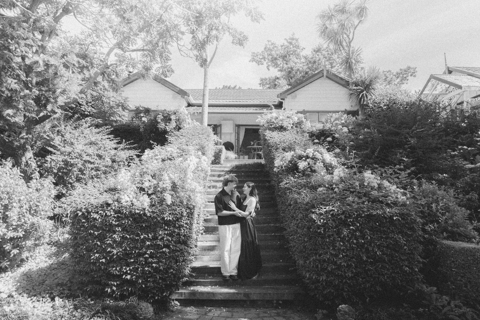 Hannah and Jackson embracing on garden steps, black and white