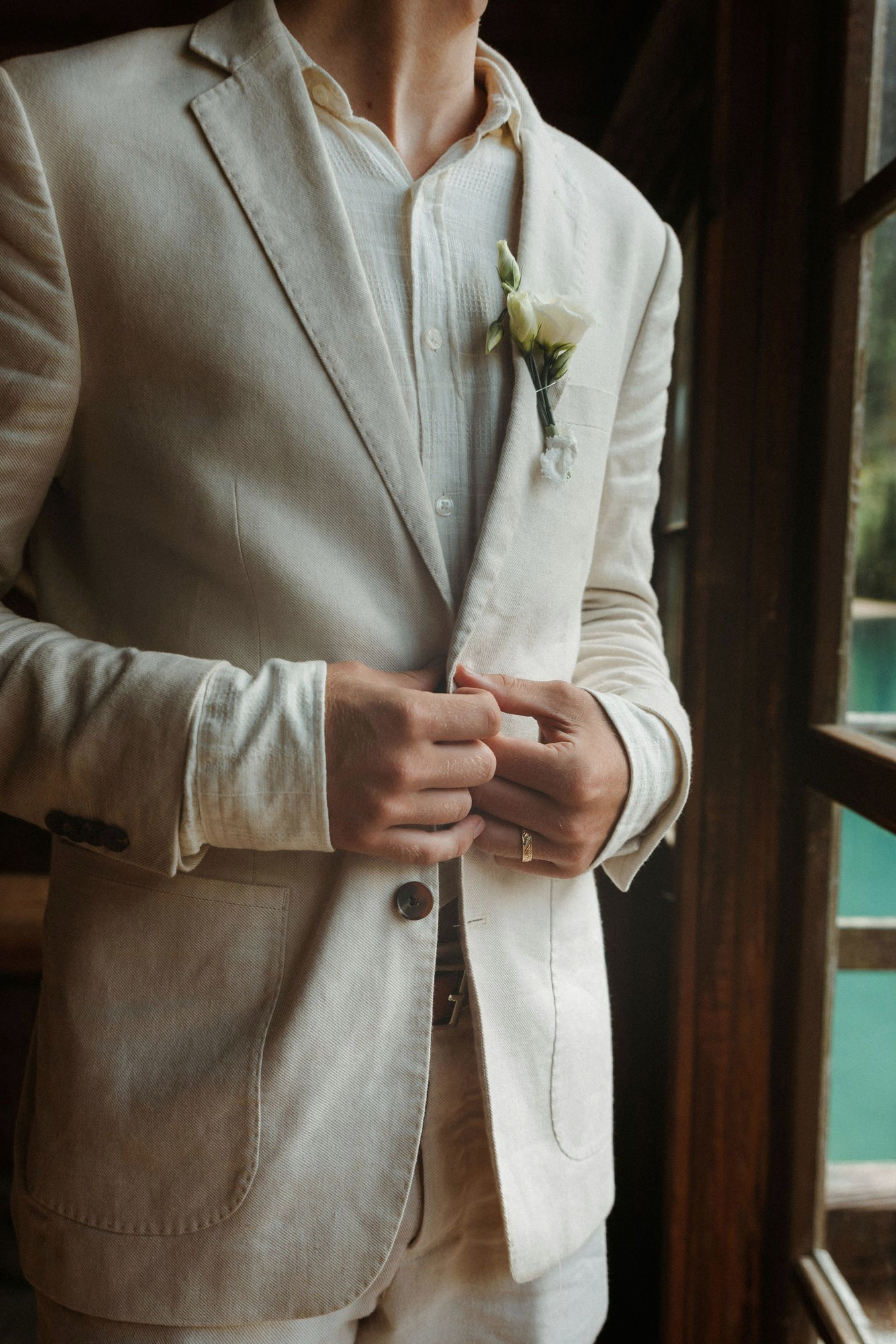 Groom getting ready by the window